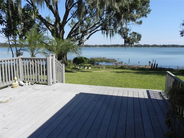 wooden terrace featuring a lawn and a water view