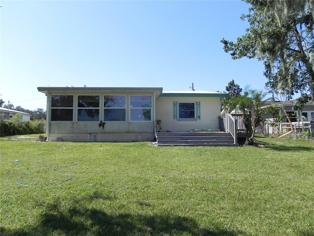back of house featuring a yard and a deck