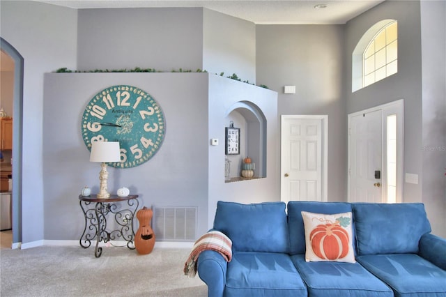 living room featuring a high ceiling and carpet flooring