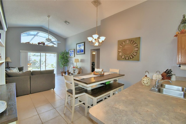 tiled dining space featuring sink, high vaulted ceiling, and ceiling fan with notable chandelier