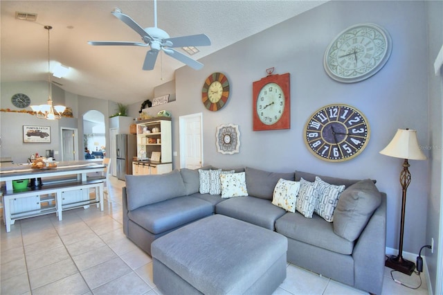 living room with high vaulted ceiling, ceiling fan with notable chandelier, and light tile patterned floors