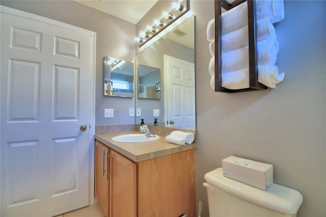 bathroom featuring toilet and vanity