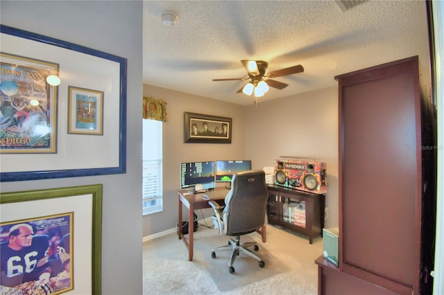 carpeted office with ceiling fan and a textured ceiling