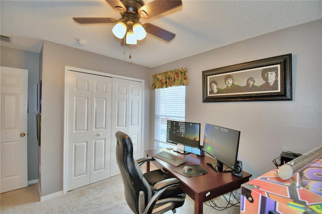 carpeted office space with ceiling fan and a textured ceiling