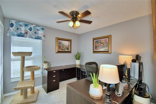 carpeted office featuring a textured ceiling and ceiling fan