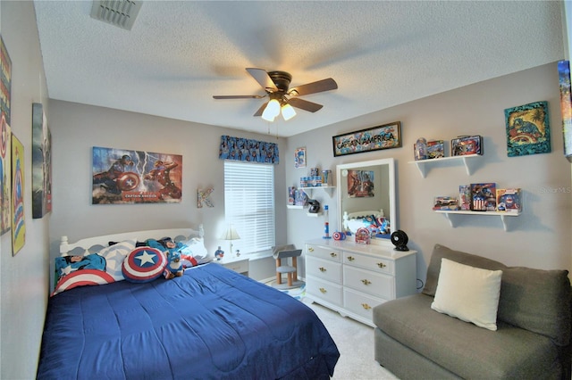 carpeted bedroom featuring a textured ceiling and ceiling fan