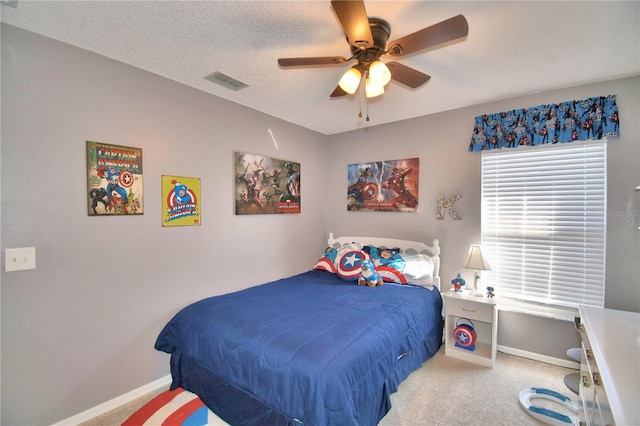 bedroom with carpet, a textured ceiling, and ceiling fan