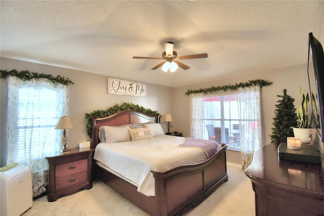 carpeted bedroom featuring ceiling fan and a textured ceiling