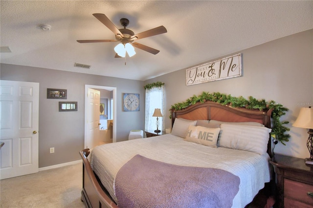 carpeted bedroom featuring connected bathroom, ceiling fan, and a textured ceiling