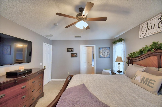 carpeted bedroom with ceiling fan and a textured ceiling