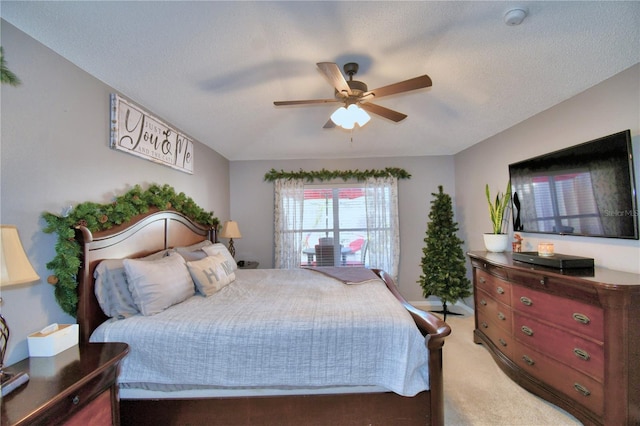 carpeted bedroom featuring ceiling fan and a textured ceiling