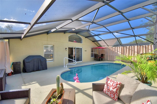 view of pool with a patio, glass enclosure, and a grill