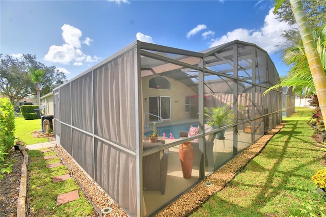 view of property exterior featuring a patio, glass enclosure, and a lawn