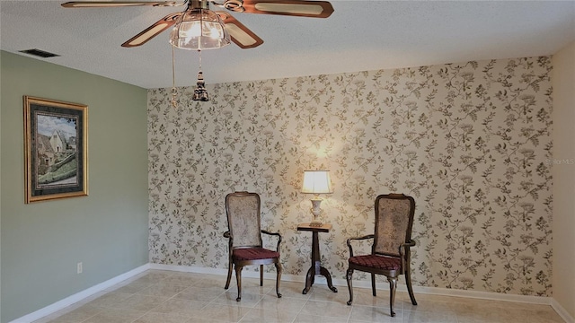 sitting room featuring a textured ceiling, ceiling fan, and light tile patterned flooring