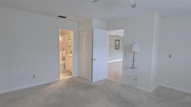 unfurnished bedroom featuring light carpet and a textured ceiling