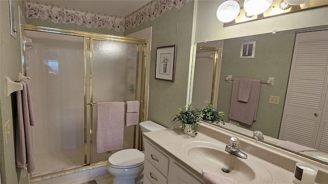 bathroom with tile patterned flooring, vanity, an enclosed shower, and toilet