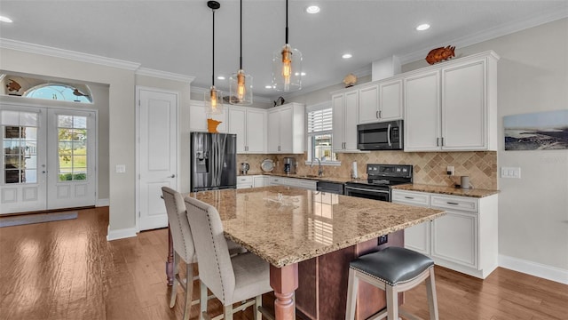 kitchen with white cabinets, appliances with stainless steel finishes, and a center island