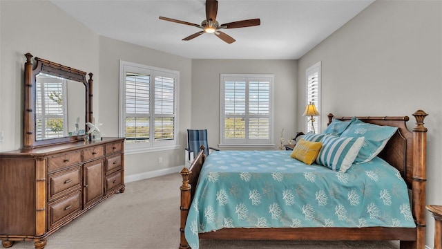 bedroom with light carpet, multiple windows, and ceiling fan