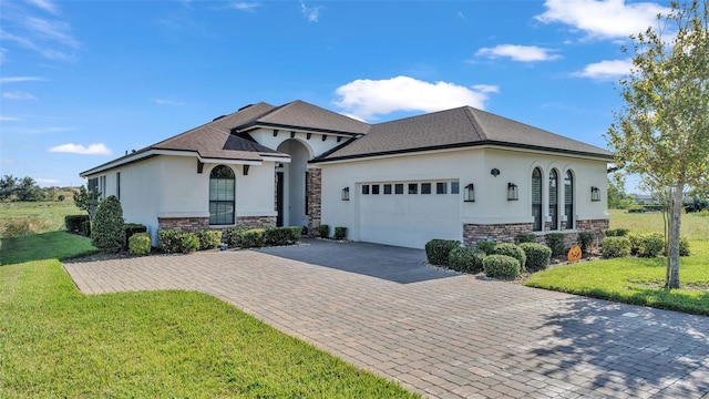 french provincial home with a front lawn and a garage