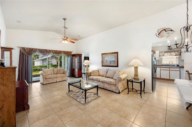 tiled living room featuring ceiling fan with notable chandelier, sink, and vaulted ceiling