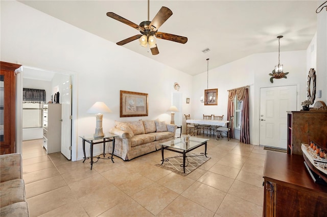 tiled living room with ceiling fan and high vaulted ceiling