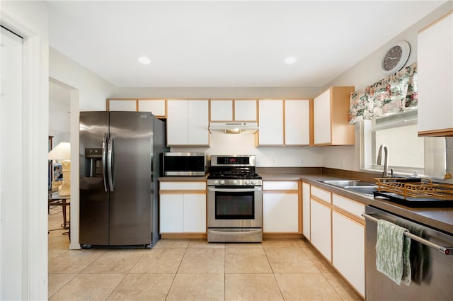 kitchen featuring light tile patterned flooring, sink, stainless steel appliances, and white cabinets