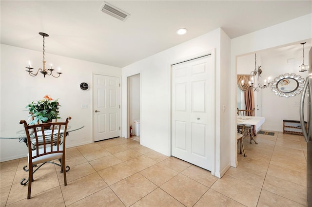 foyer entrance with an inviting chandelier and light tile patterned floors