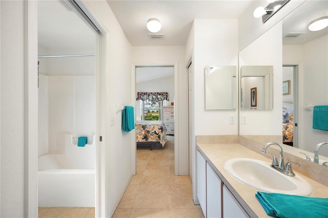 bathroom with shower / tub combination, vanity, lofted ceiling, and tile patterned floors