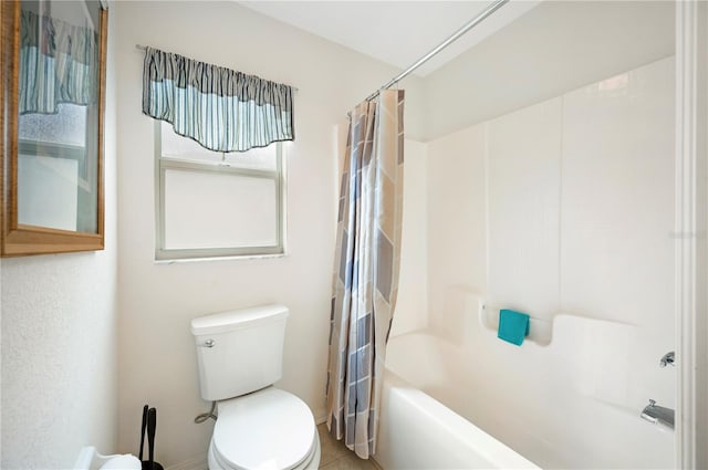 bathroom featuring tile patterned flooring, shower / tub combo, and toilet