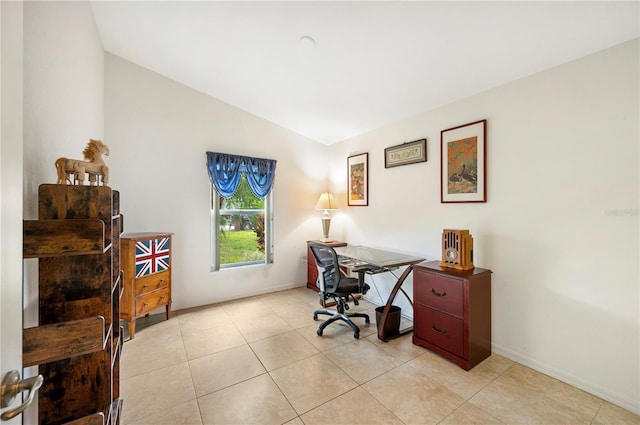 office featuring light tile patterned floors, baseboards, and vaulted ceiling