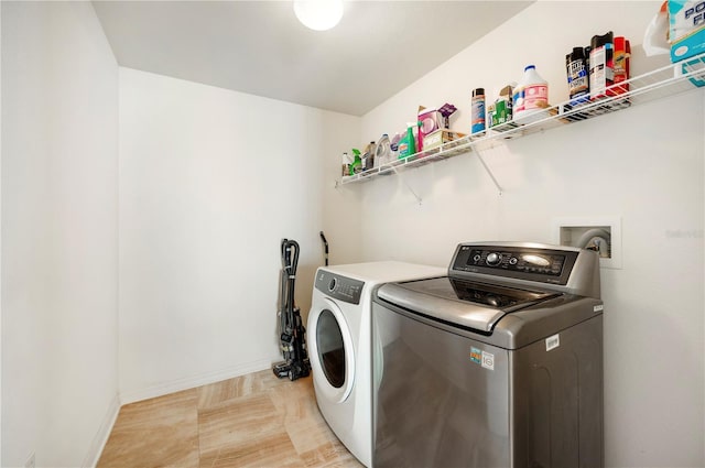 washroom featuring baseboards, separate washer and dryer, and laundry area