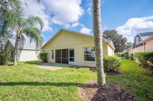 back of property with a lawn and a patio area