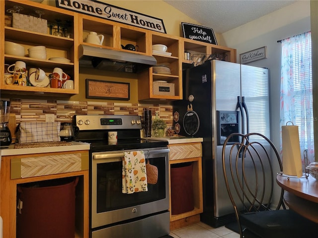 kitchen featuring light tile patterned flooring, appliances with stainless steel finishes, a textured ceiling, and tasteful backsplash