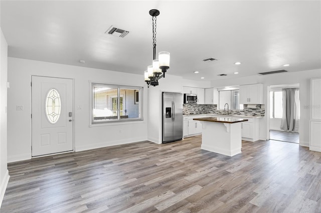 kitchen featuring a wealth of natural light, appliances with stainless steel finishes, light hardwood / wood-style flooring, and white cabinets