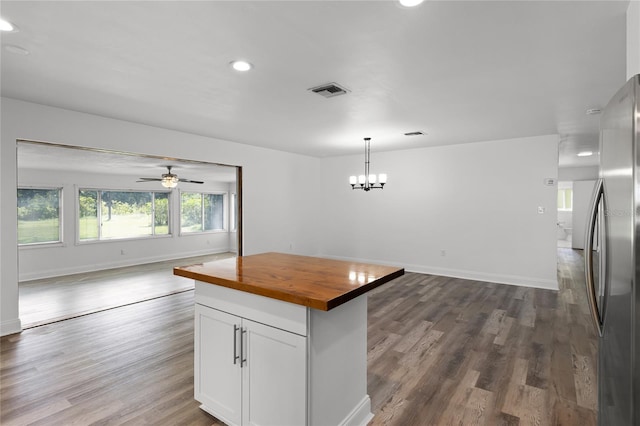 kitchen with a kitchen island, dark hardwood / wood-style flooring, wooden counters, pendant lighting, and white cabinets