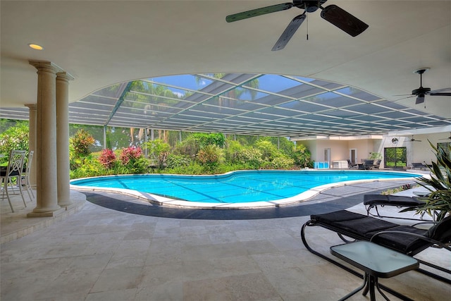 view of swimming pool with a patio, glass enclosure, and ceiling fan