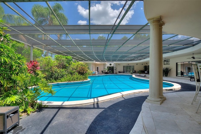 view of swimming pool featuring a patio area, ceiling fan, and glass enclosure