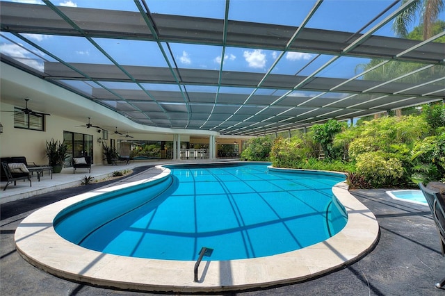 view of pool with ceiling fan, a lanai, and a patio area