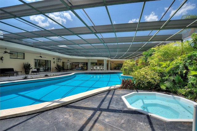 view of pool with an in ground hot tub, a patio area, glass enclosure, and ceiling fan