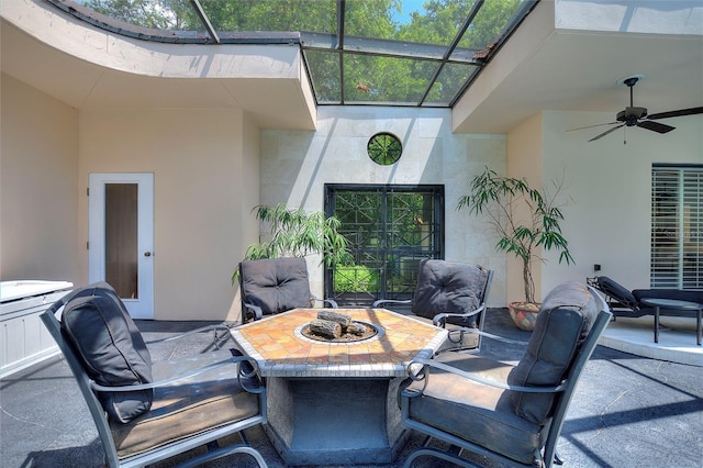 view of patio / terrace featuring ceiling fan, a fire pit, and a lanai