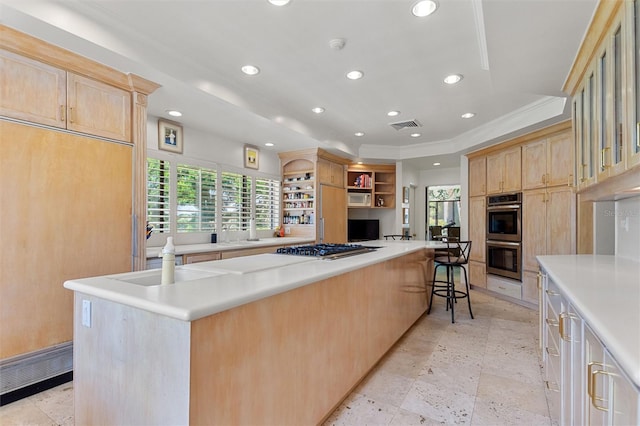 kitchen featuring a large island, appliances with stainless steel finishes, a breakfast bar area, and ornamental molding