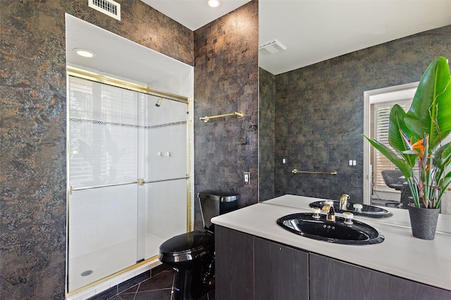 bathroom with vanity, tile patterned flooring, toilet, and a shower with door