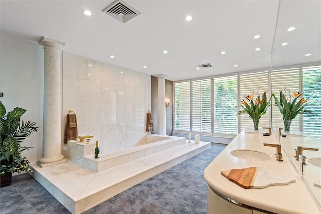 bathroom featuring vanity, ornate columns, a tub to relax in, and tile patterned floors