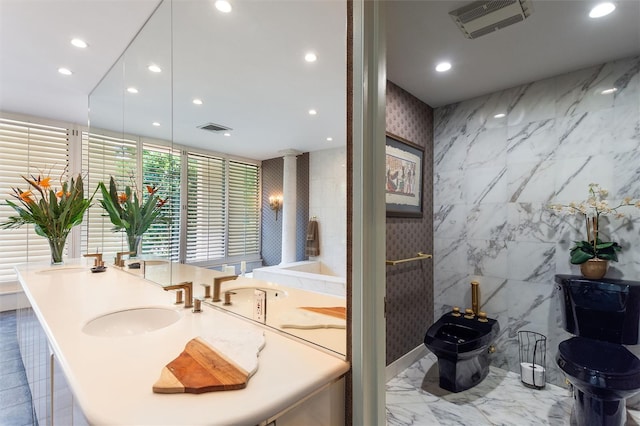 bathroom with decorative columns, toilet, tile walls, and sink