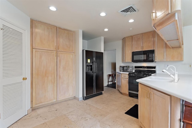 kitchen with light brown cabinets, black appliances, and sink