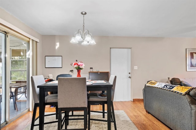 dining area with an inviting chandelier and light hardwood / wood-style flooring