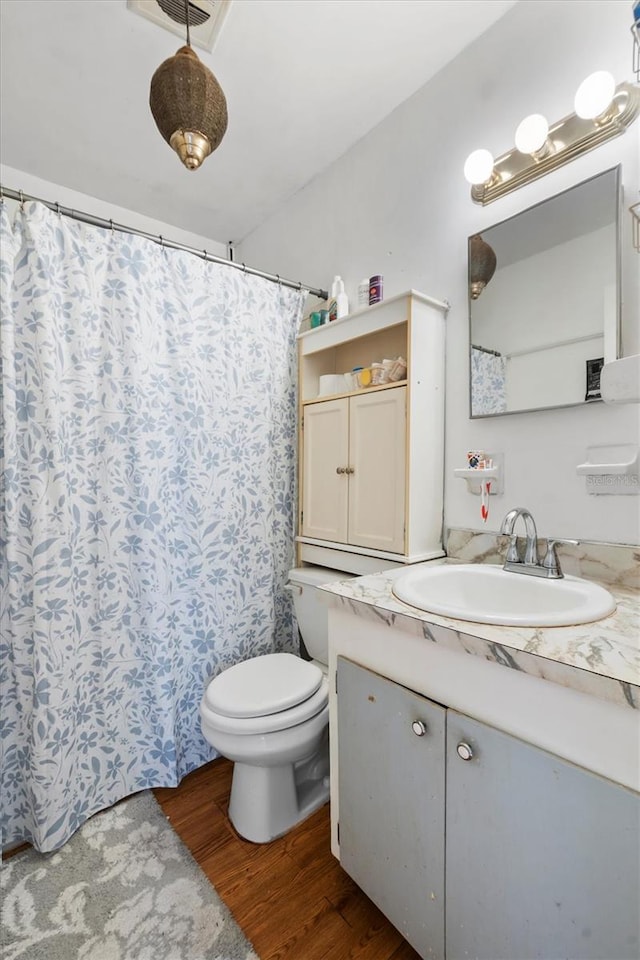 bathroom with hardwood / wood-style flooring, vanity, and toilet