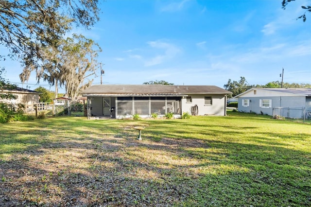 back of property with a lawn and a sunroom