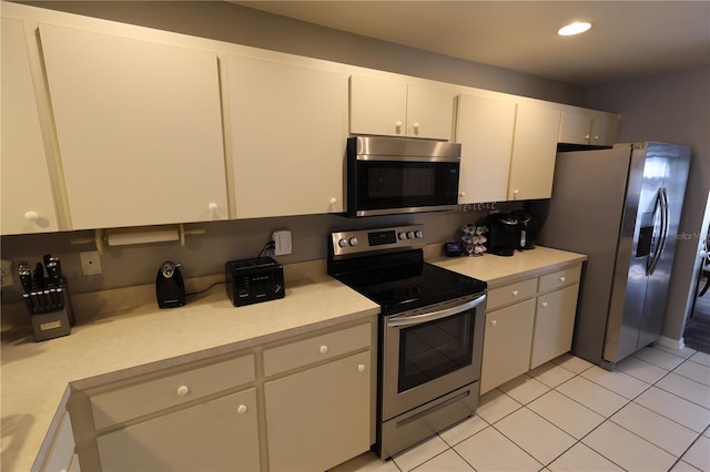 kitchen with white cabinetry, appliances with stainless steel finishes, and light tile patterned floors