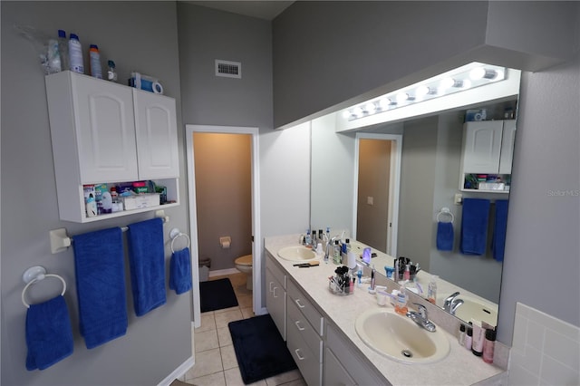 bathroom with vanity, toilet, and tile patterned floors